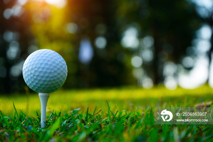 日落时，模糊的高尔夫球杆和高尔夫球在草地上靠近。高尔夫球在高尔夫球场上靠近