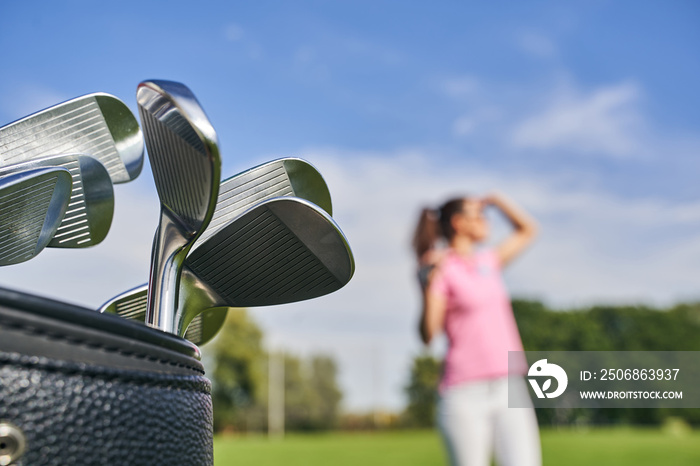 Dark-haired lady golfer on the driving range