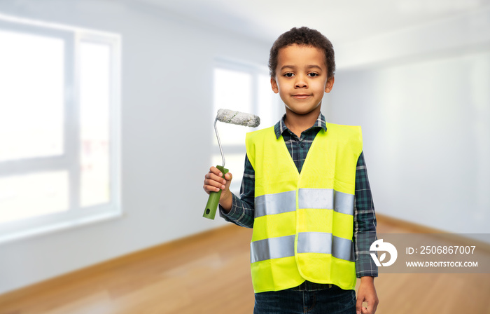 building, construction and profession concept - smiling little boy in yellow safety vest with paint 