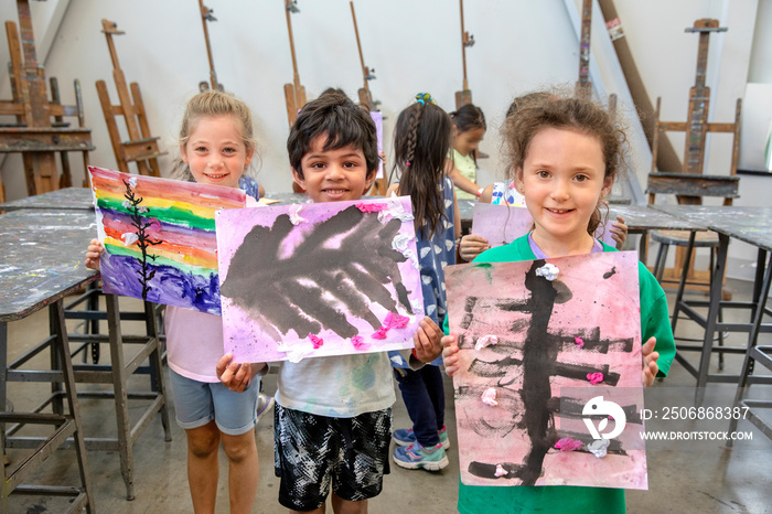 Children holding their finished paintings