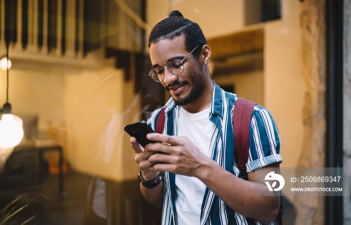 Smiling man messaging on mobile phone