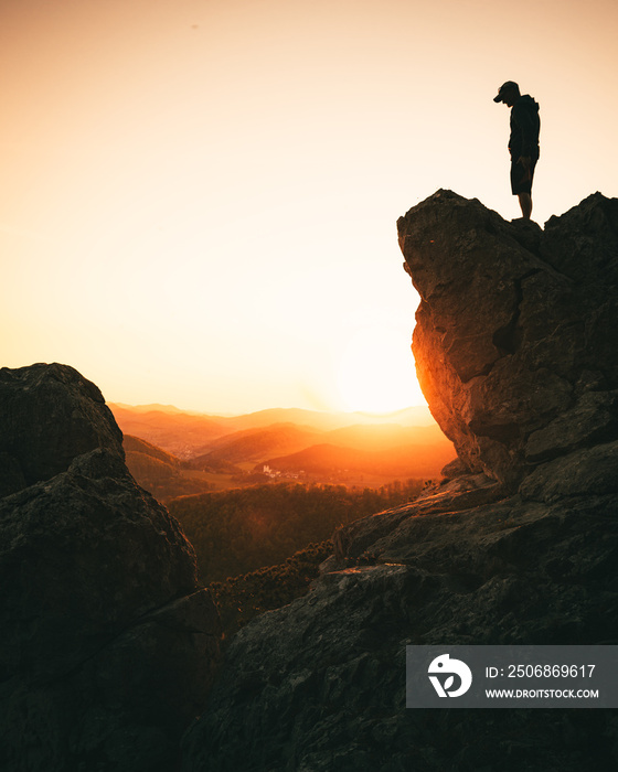 man standing on top of mountain during sunset in summer