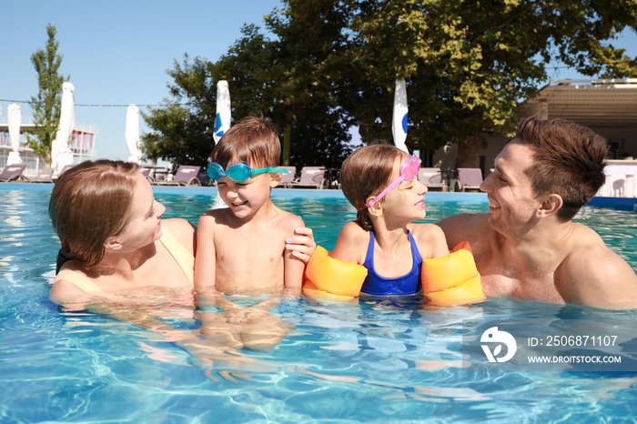 Happy family in swimming pool on summer day