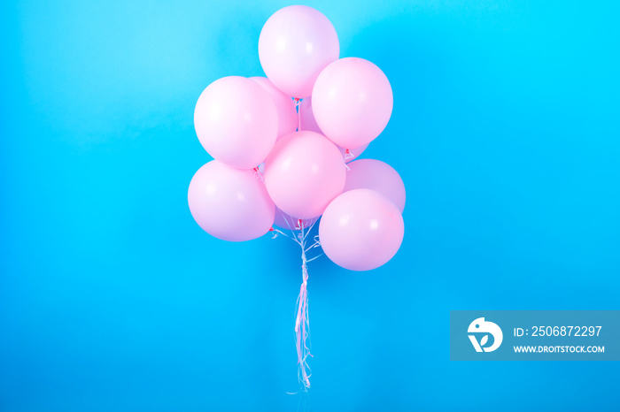 蓝色（青色）背景上的粉色生日气球，带有文本复制空间。粉色粉彩派对气球