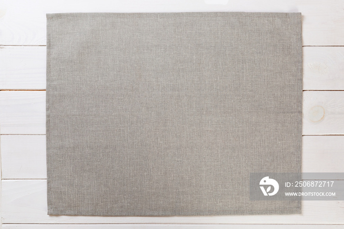 gray cloth napkin on white rustic wooden background top view with copy space