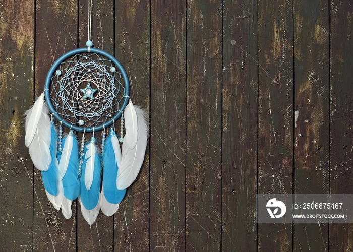 Beautiful handmade boho dreamcatcher with blue feathers and copy space.