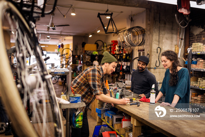 Mechanic talking with customers in bicycle shop