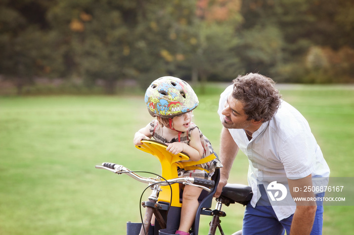 Father and daughter (2-3) on bicycle in Prospect park