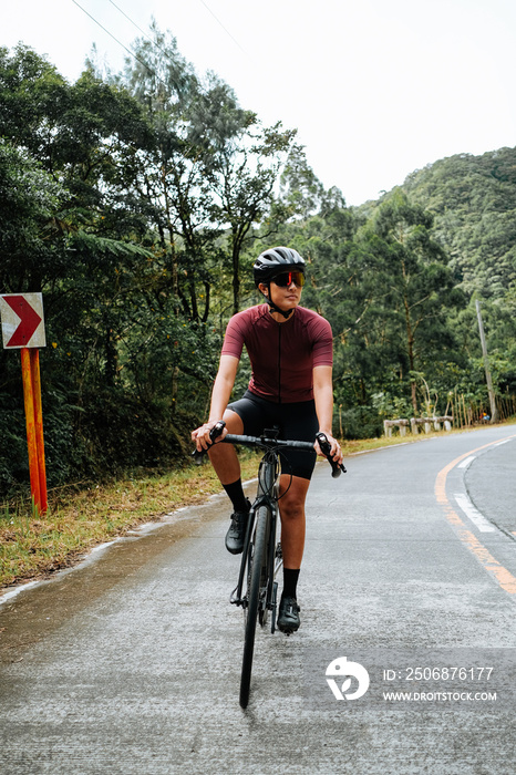 A young female cyclist riding her gravel bike in the mountains.