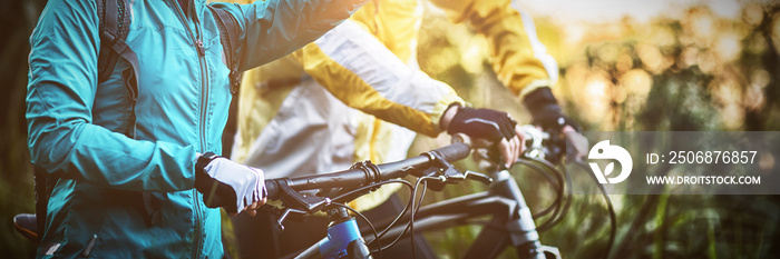 Biker couple with mountain bike pointing in distance