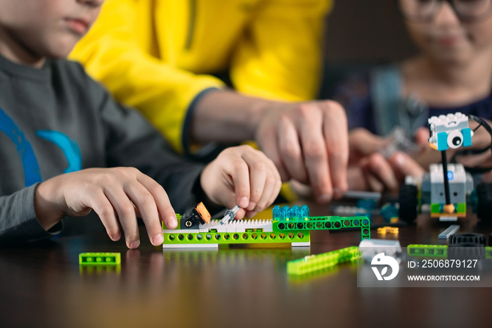 Kids creating robots with teacher. Early development, diy, innovation, modern technology concept.