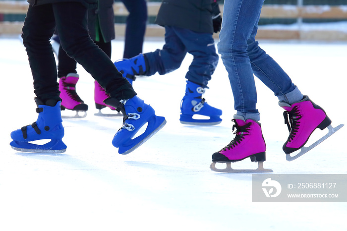 feet of different people skating on the ice rink