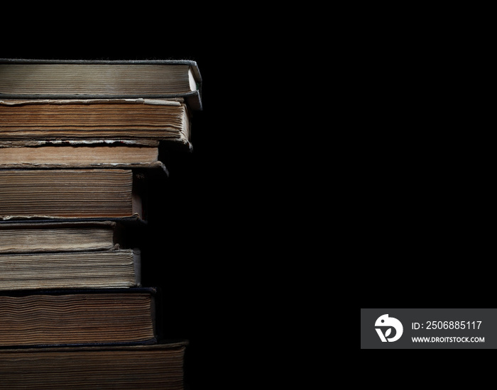 Old books in pile on a black background