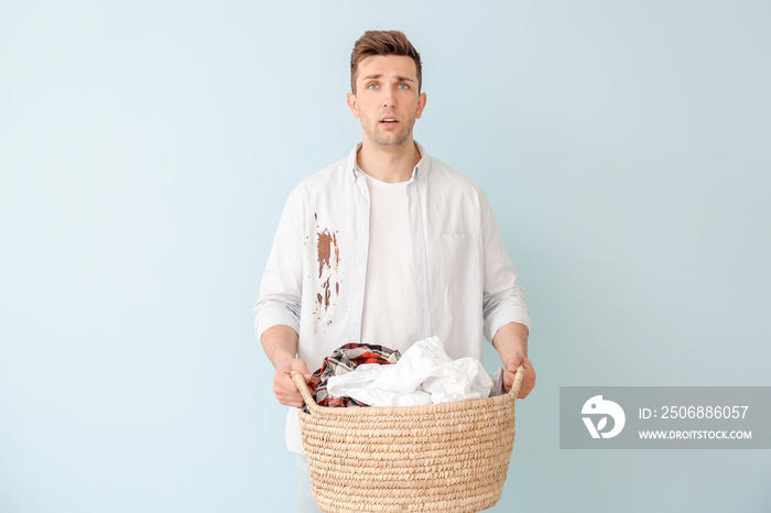 Troubled man with dirty clothes on color background