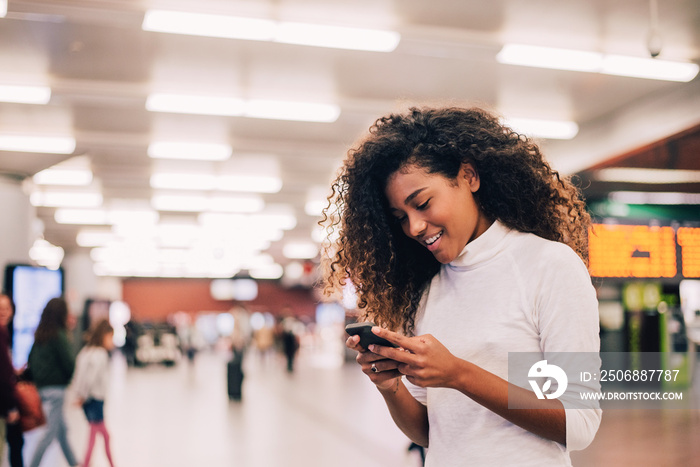 Gorgeous girl with curly hair using phone. Close-up.