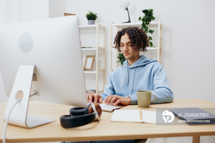 guy with curly hair sitting in front of the computer internet online technologies