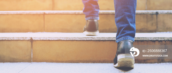 Close up legs shoes of young business man One person walking stepping going up the stairs in modern 