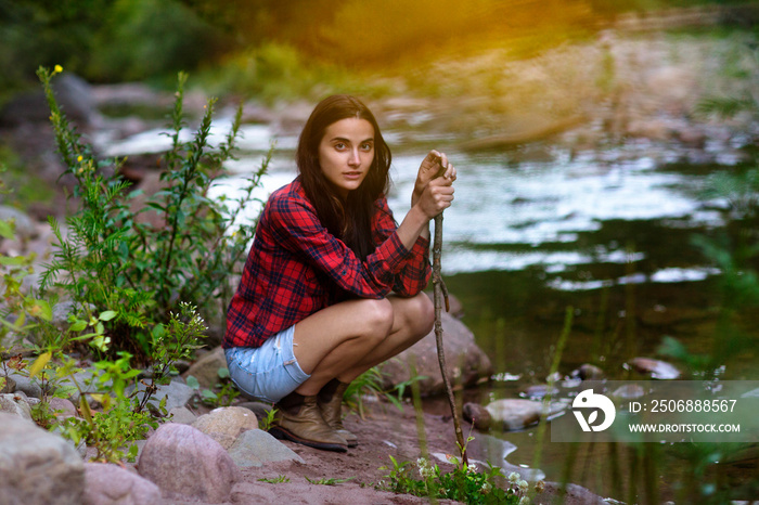 Young woman crouching on riverbank