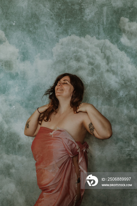 portrait of a white woman laughing with eyes closed hands in hair