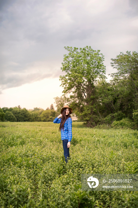 Portrait of young woman standing in meadow