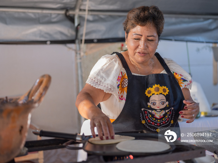 Indigenous woman cooking handmade tortillas on a comal