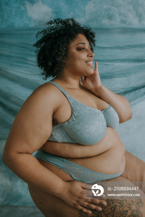 portrait of a plus size afro indigenous person sitting hand on face