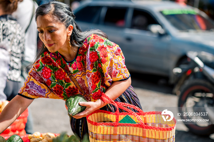 Mujer escoge los vegetales más frescos en en el mercado.