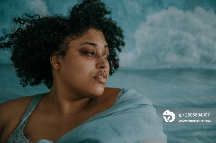 close up portrait of a plus size afro indigenous persons face looking sideways