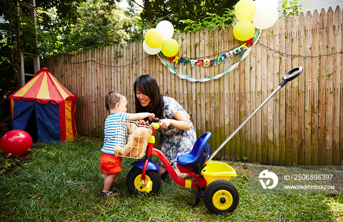 Baby boy playing with tricycle