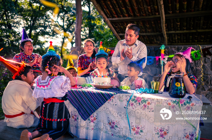 Familia multigeneracional celebrando cumpleaños en el jardín.