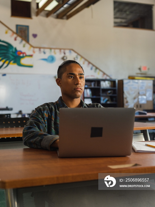 Native student in class while on his computer