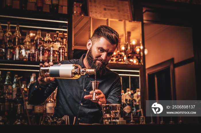 Elegant happy bar owner is making special drink for his customers at his own bar.