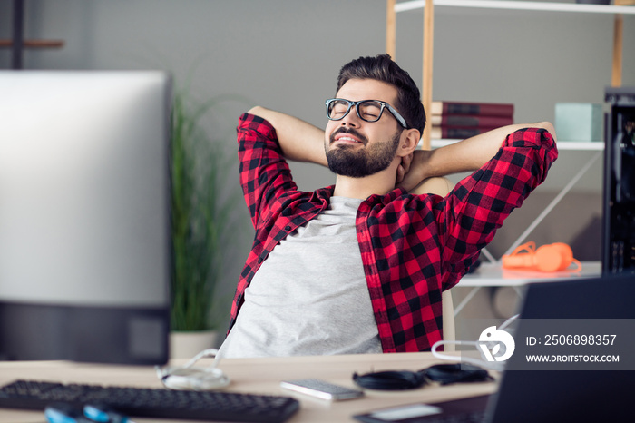 Portrait of attractive cheerful dreamy guy coder tech support manager sitting in chair resting indoo