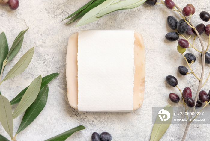 Soap bar on a marble table with olive branches, top view. mockup