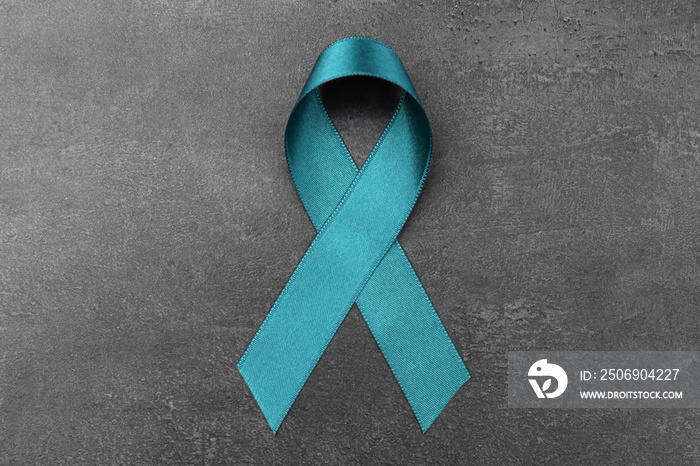 Sea-green ribbon on grey background. Ovarian cancer and gynecological disorders concept