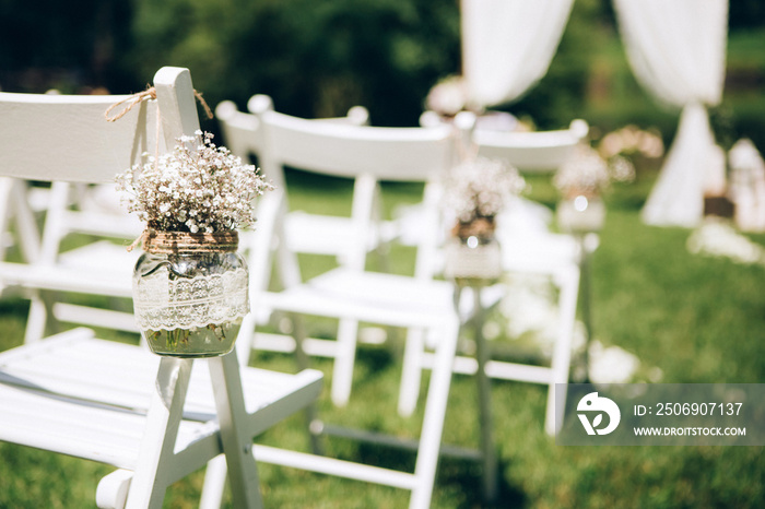 Outgoing wedding ceremony. Decor Studio. white wooden chairs on a green lawn. Wedding festal arch. W