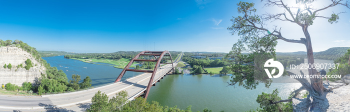 Panoramic Pennybacker Bridge over Colorado river and limestone cliff in Austin