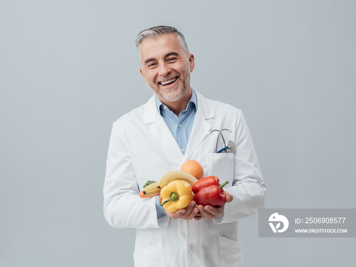 Smiling nutritionist holding fresh vegetables and fruit