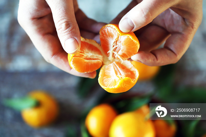 Selective focus. male hands hold a split mandarin