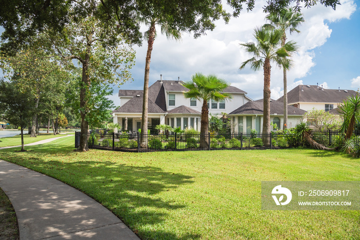 Shady path leads to residential houses by the lake in Houston, Texas, USA.