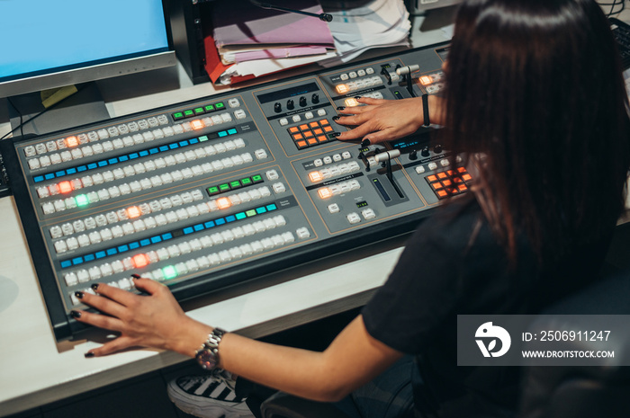 Young beautiful woman working in a broadcast control room on a tv station