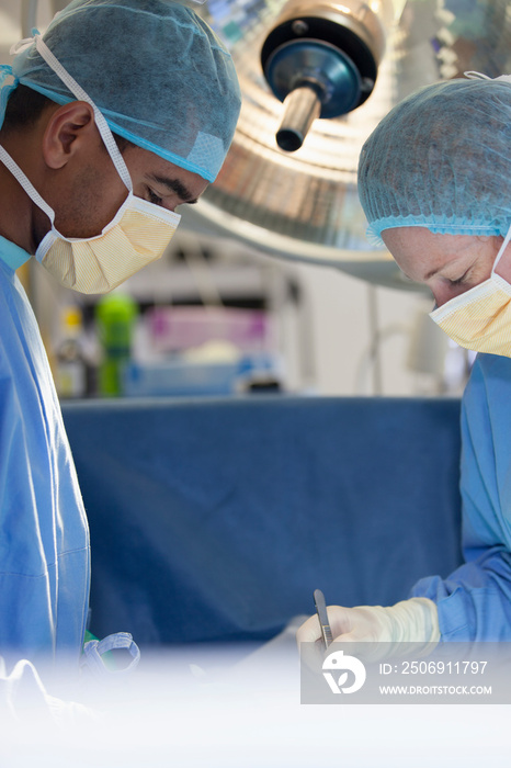 Focused surgeons performing surgery in hospital operating room