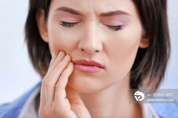 Beautiful young woman suffering from toothache, close up