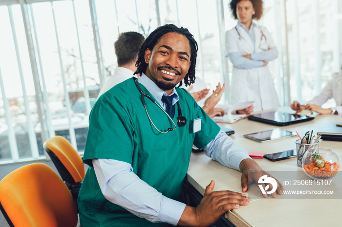 Handsome african american medical doctor with colleagues in background