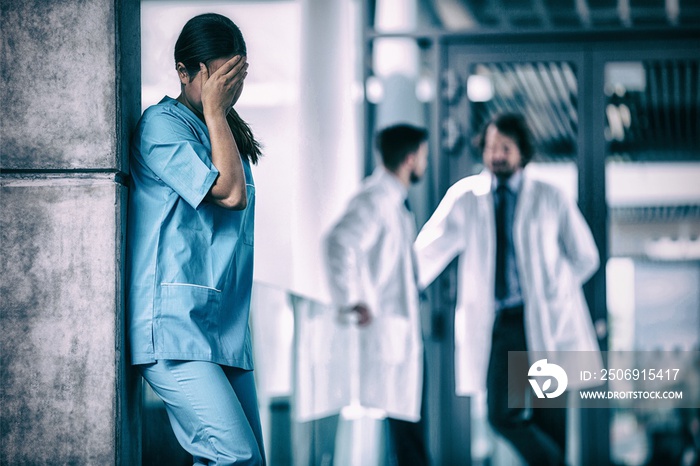 Stressed nurse standing in hospital