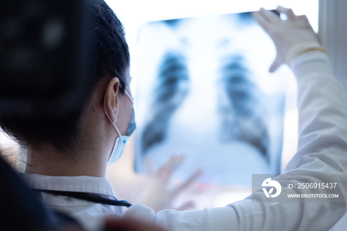 Pulmonologist looking at lung x-ray prescribing treatment to patient, healthcare