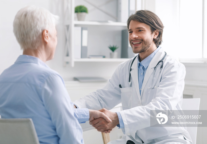 General practitioner shaking hands with healthy patient