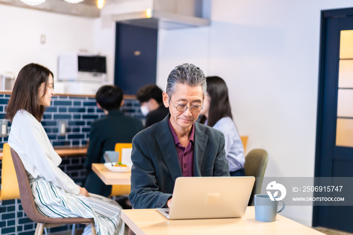 カフェで仕事をする中年男性