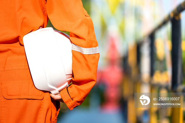 Oil field operator or worker is holding white safety hardhat, prepare to start the job on working pl