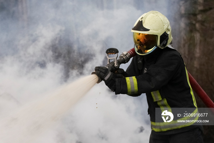 Brave firefighter saving burning building. Firefighter work concept. Firefighter are using water in 